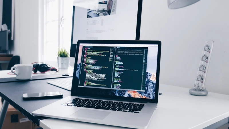 Person working on FAQ content creation on laptop in modern office workspace